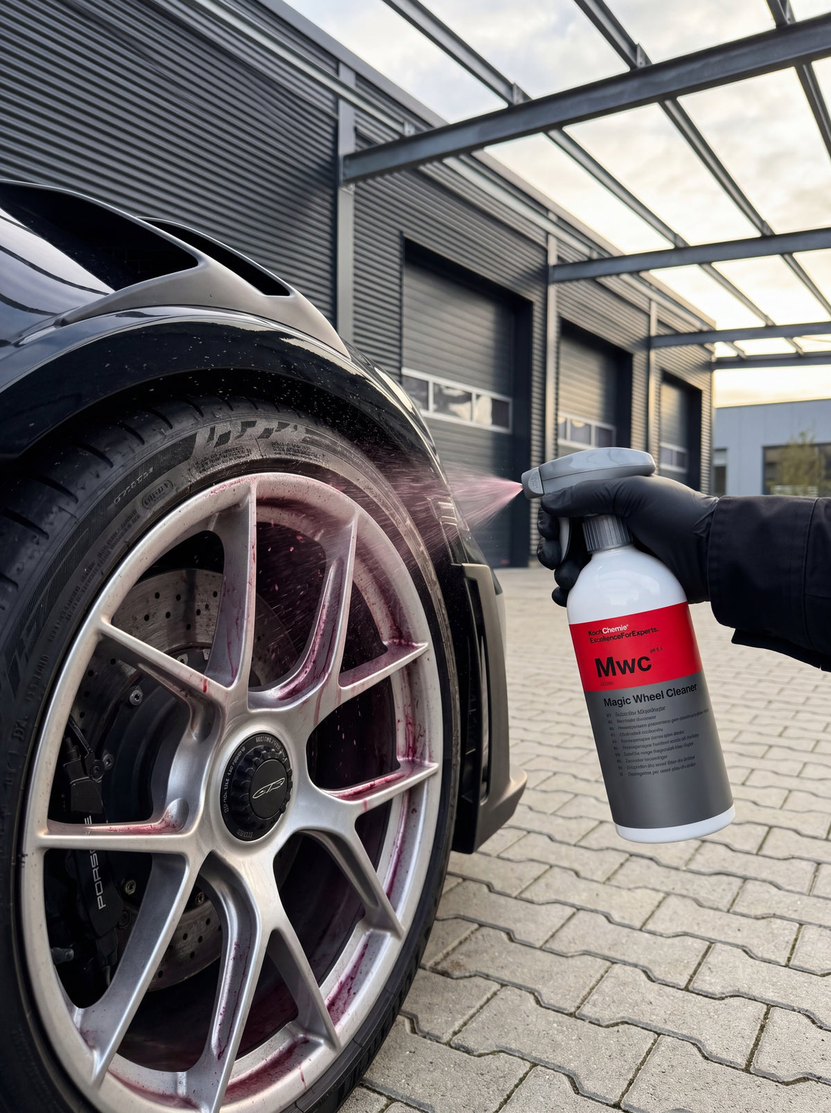 Koch-Chemie Magic Wheel Cleaner wird auf eine Porsche-Felge gesprüht, rot-violetter Farbumschlag durch Reaktion mit Bremsstaub sichtbar