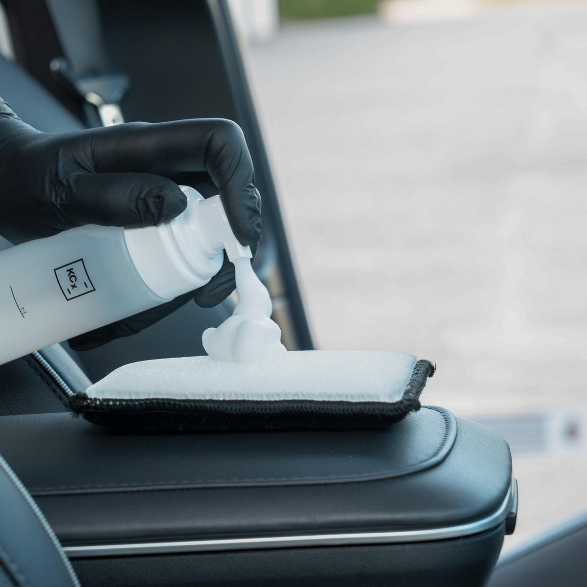 detiiling1.comLOURLOCK Leather Cleaner (Mild) — cleaning foam on the pad next to a black leather armrest