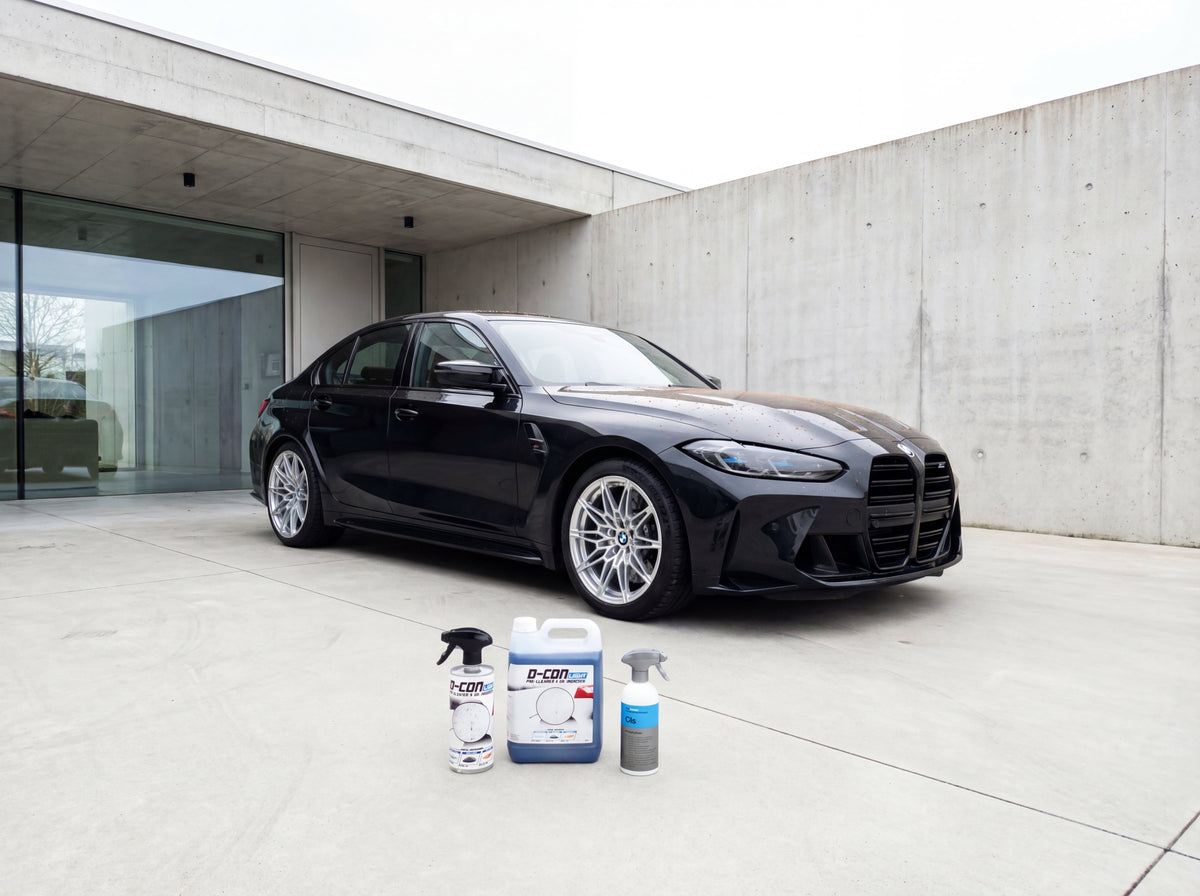 Schwarzer BMW M3 mit silbernen OEM-Felgen und Dekontaminationsprodukten auf Betonauffahrt
