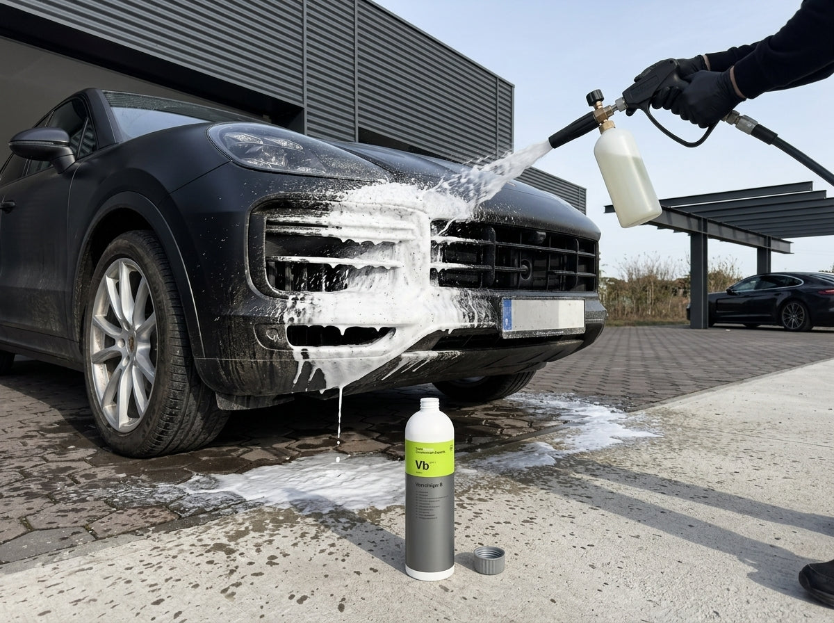 Schaumkanone sprüht Koch-Chemie Vorreiniger B auf dunklen Porsche Cayenne vor dem Warehouse — Vorwäsche-Start