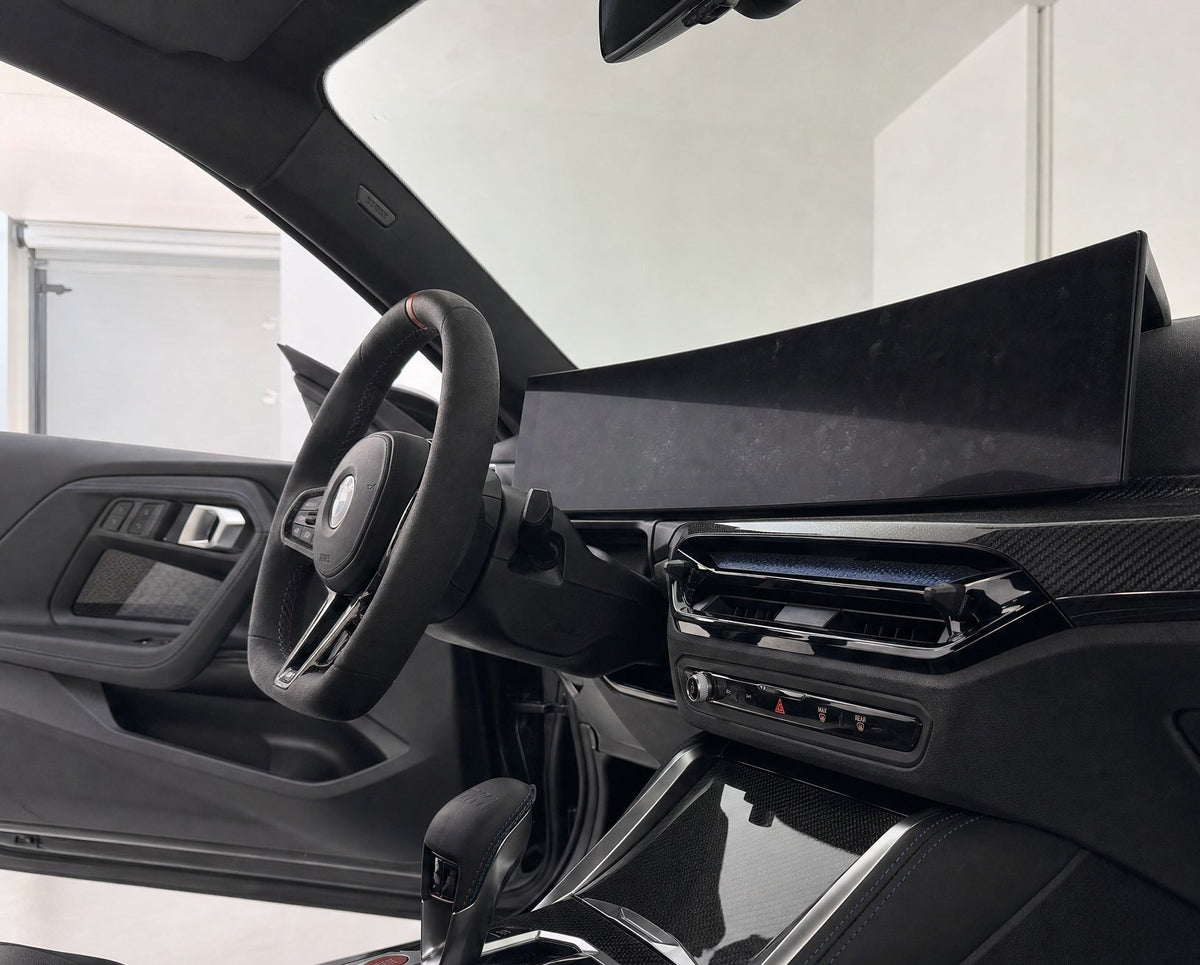 detiiling1.comckpit-Display im BMW M2 mit Fingerprint-Schleier im Streiflicht vor der Reinigung