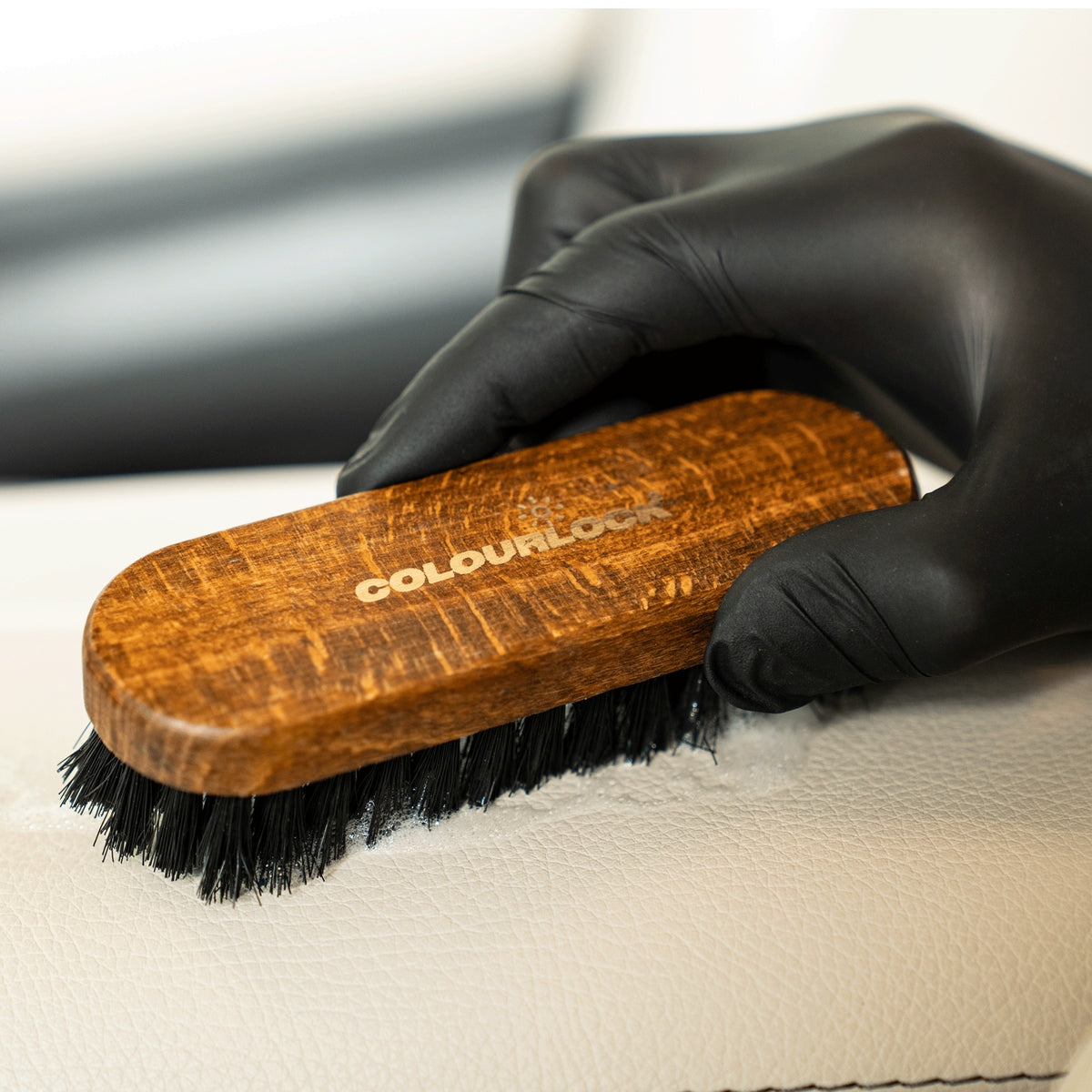 detiiling1.comLOURLOCK Leather Cleaning Brush cleaning a light leather surface